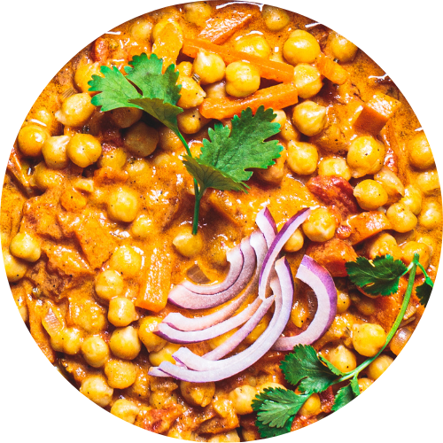 A closeup of a chickpea curry garnished with red onion